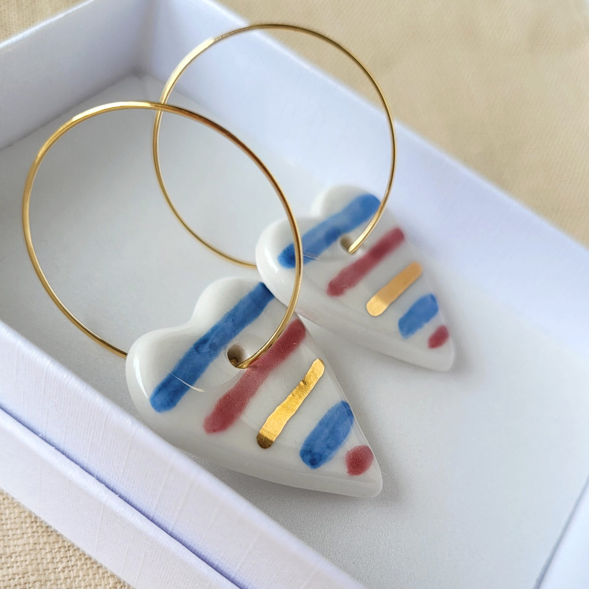 Porcelain dangle earrings with gold "White hearts with stripes"