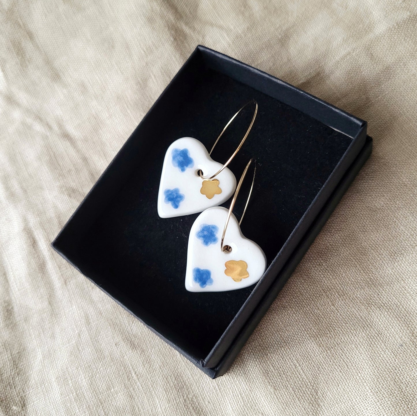 Porcelain dangle earrings with gold "White hearts with dark blue clouds"