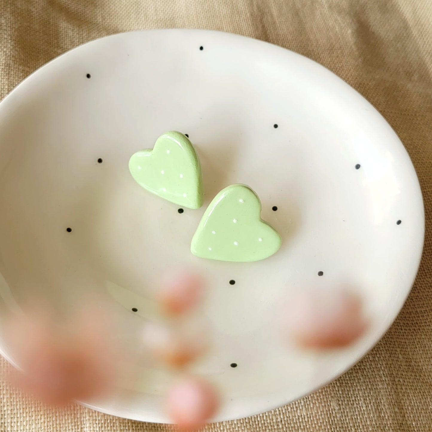 Ceramic stud earrings "Light green hearts with white dots"