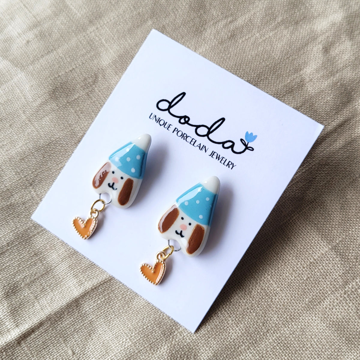 Porcelain stud earrings "Puppies with blue hats and orange hearts"