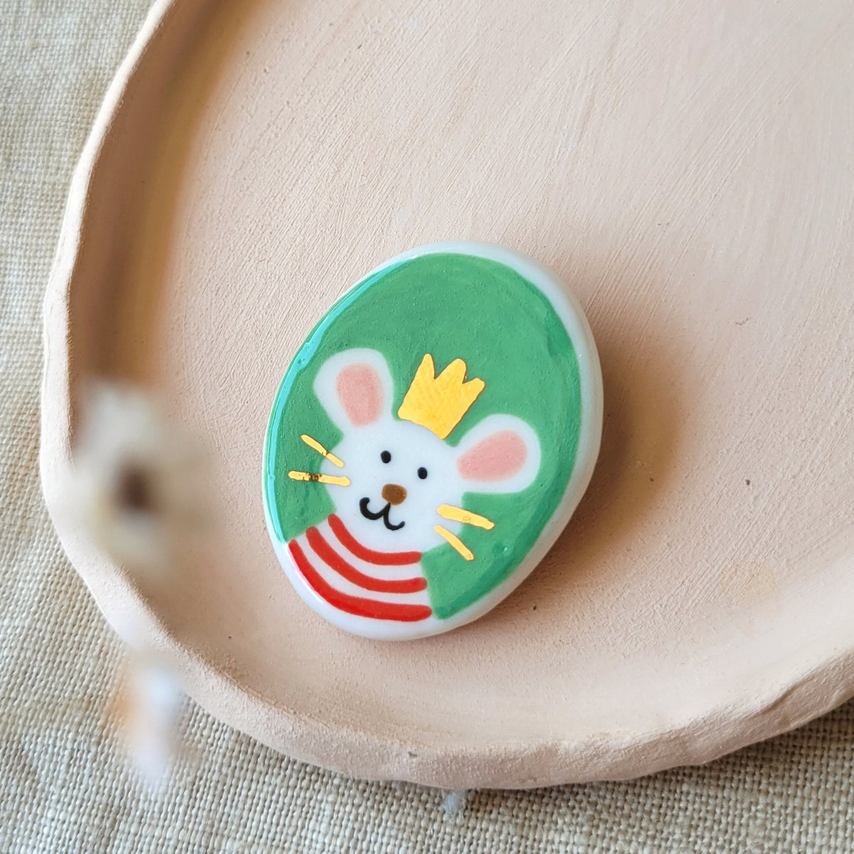 Porcelain brooch with gold "Oscar"