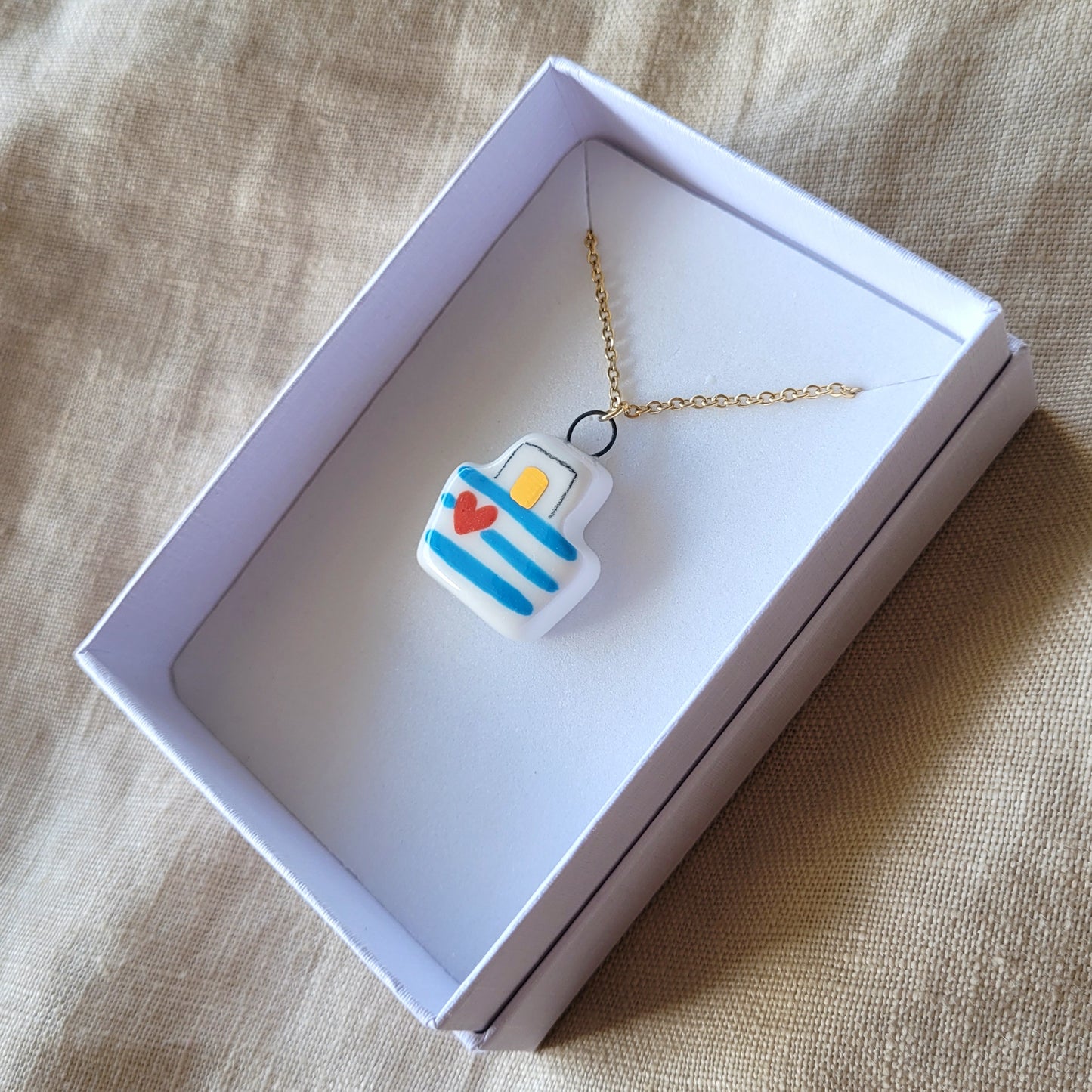 Porcelain necklace with gold "Boat with blue stripes"