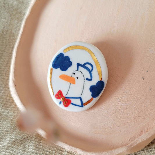 Porcelain brooch with gold "George"