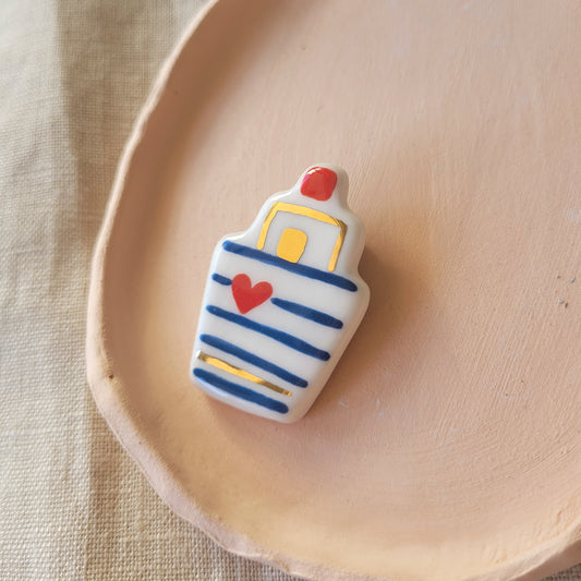 Porcelain brooch with gold "Boat with dark blue stripes"