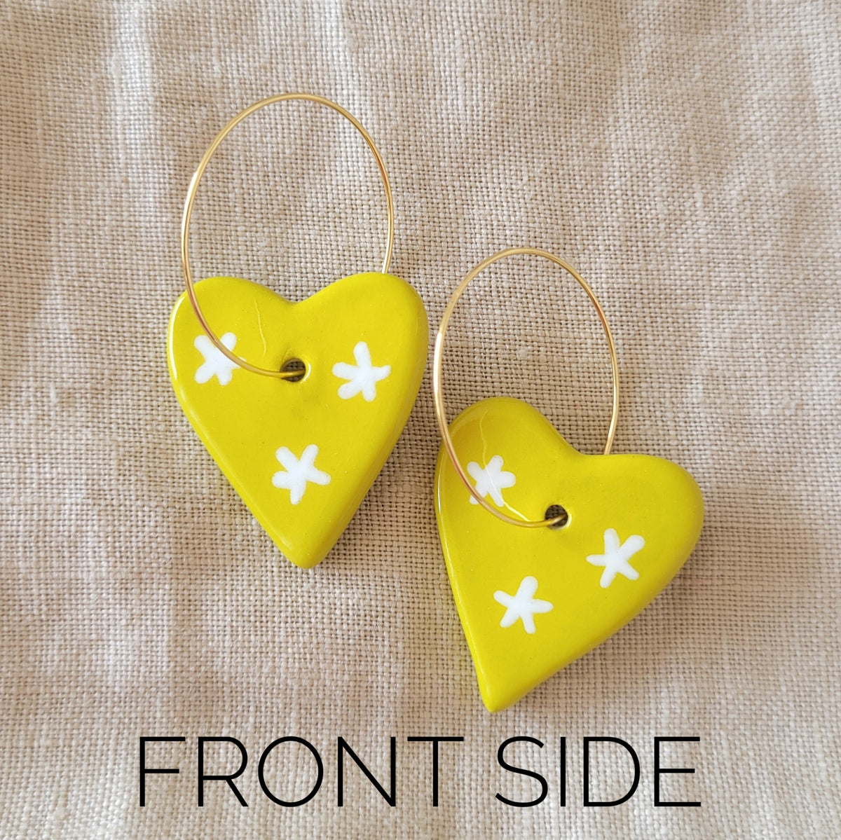 Ceramic dangle earrings "Greenish yellow hearts with white stars"