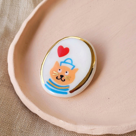 Porcelain brooch with gold "George"