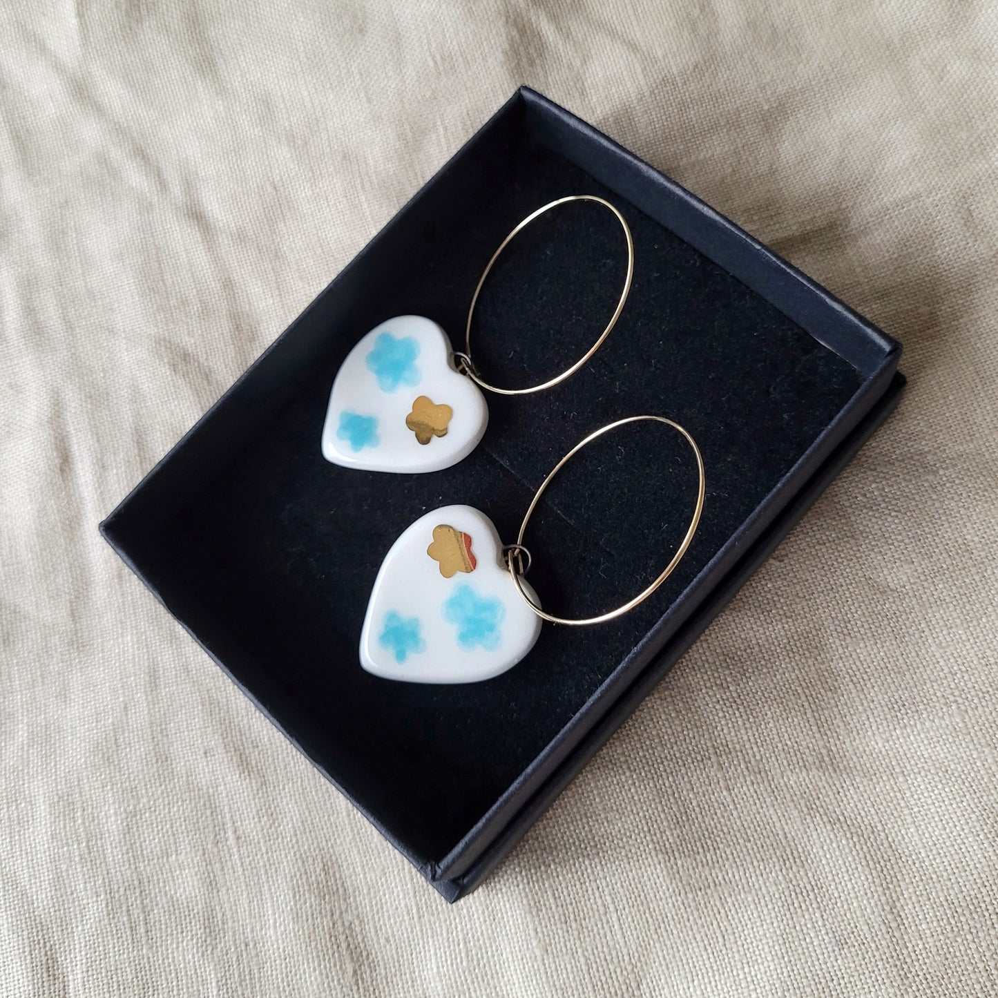 Porcelain dangle earrings with gold "White hearts with light blue clouds"