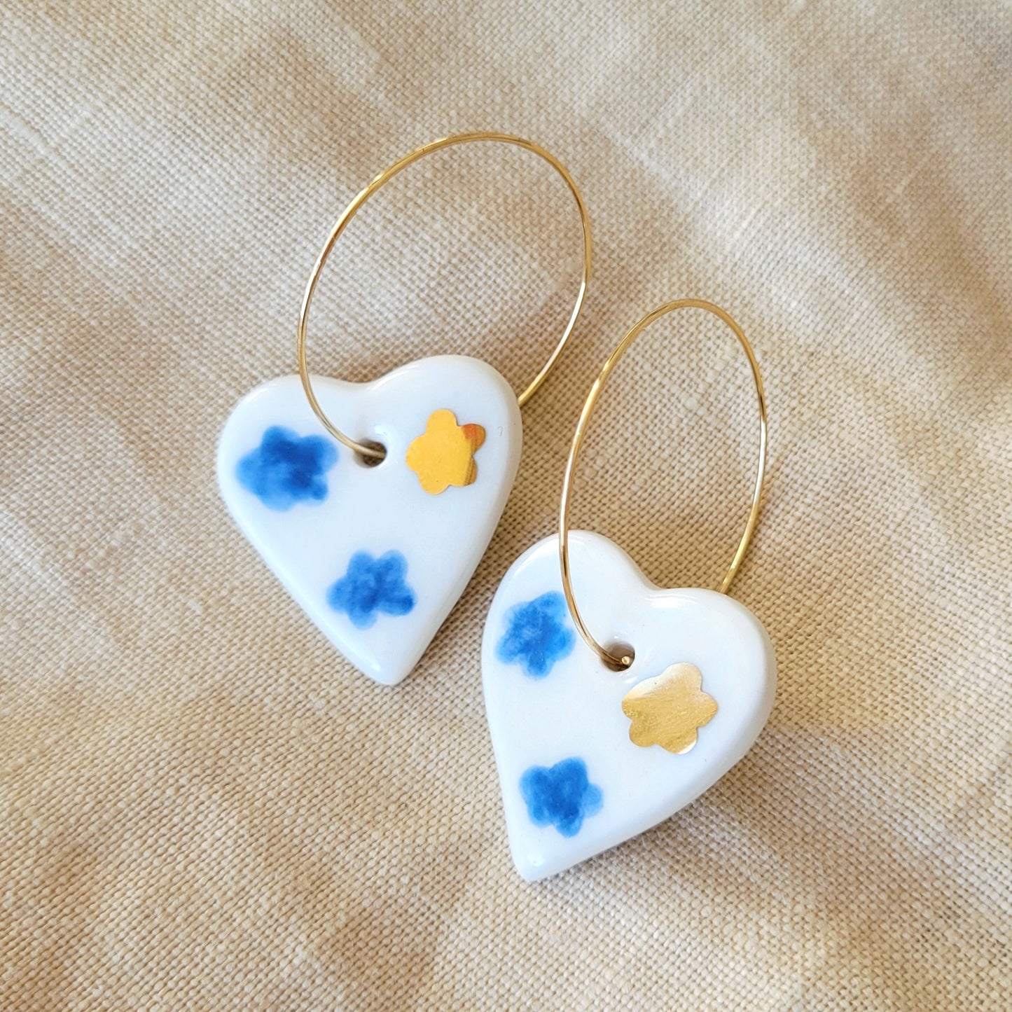 Porcelain dangle earrings with gold "White hearts with dark blue clouds"