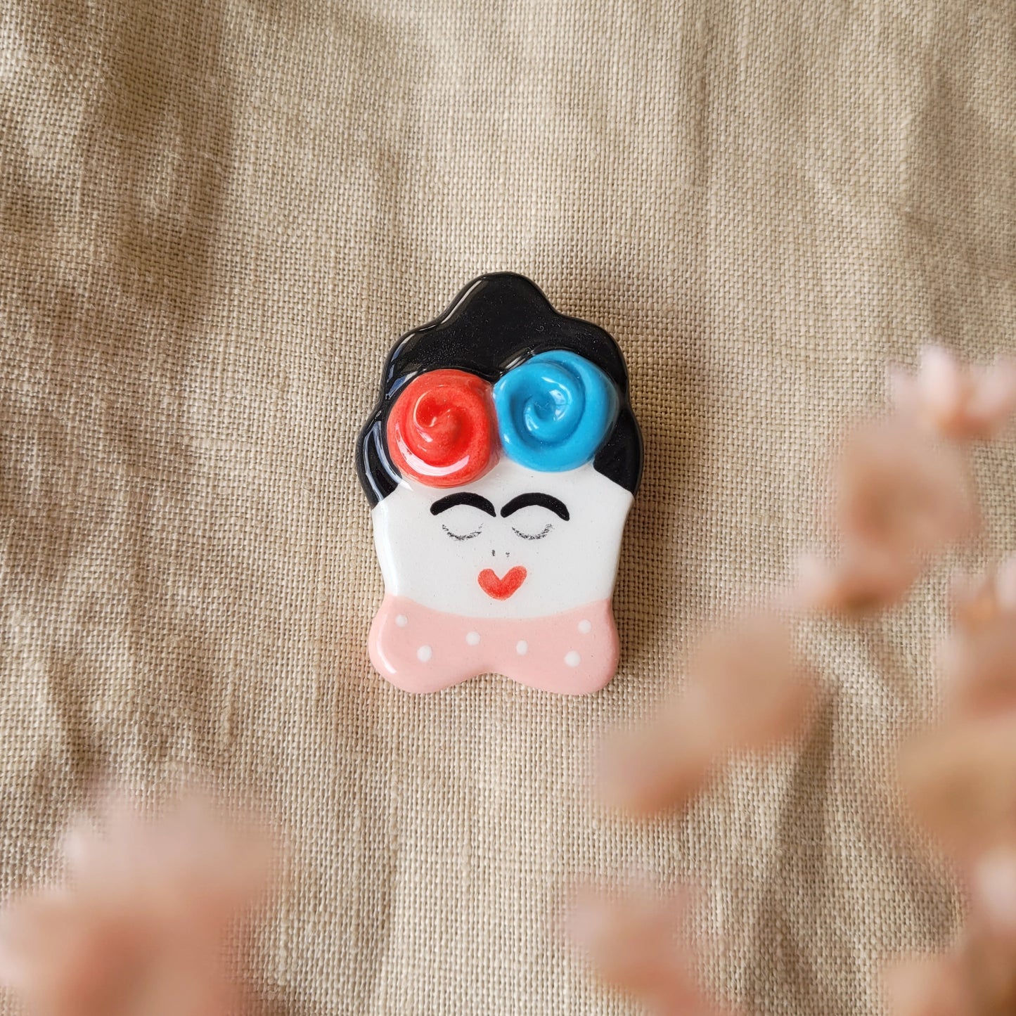 Ceramic brooch "Girl with red and blue flowers"