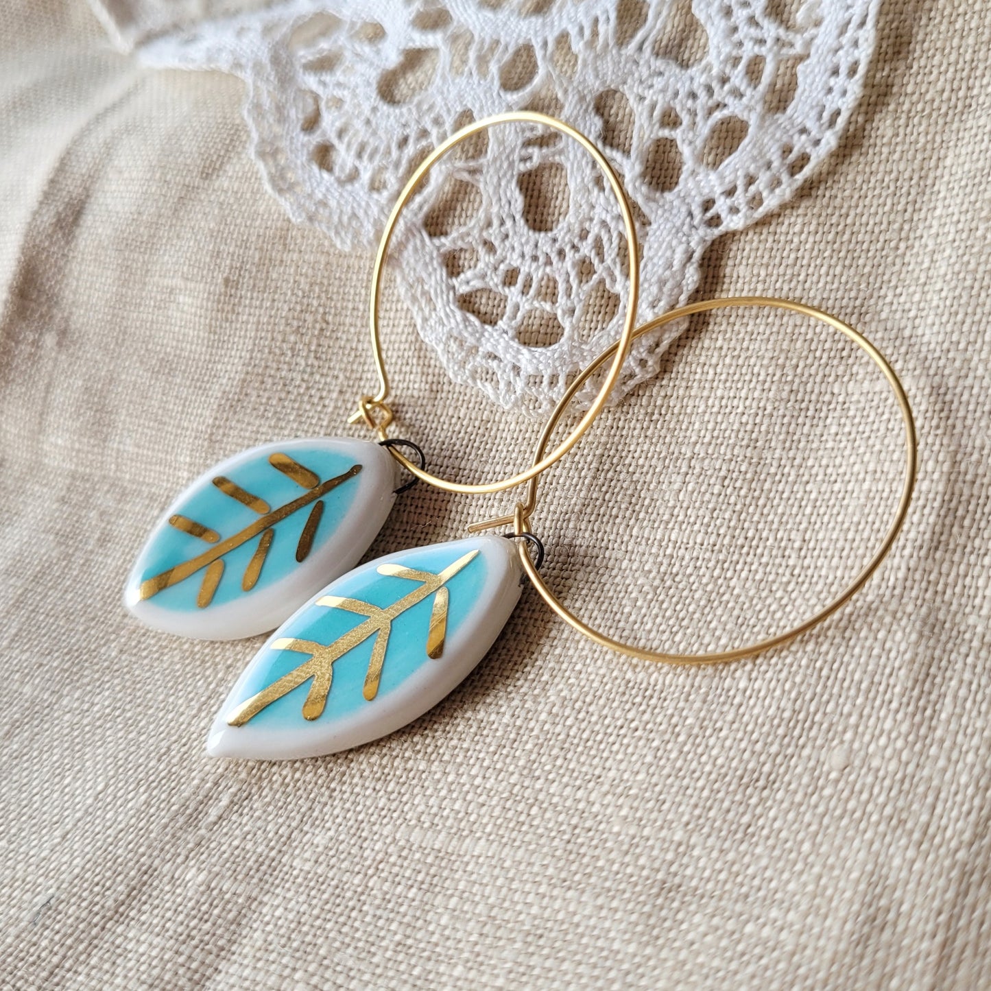 Porcelain dangle earrings with gold "Small white and light blue leaves"