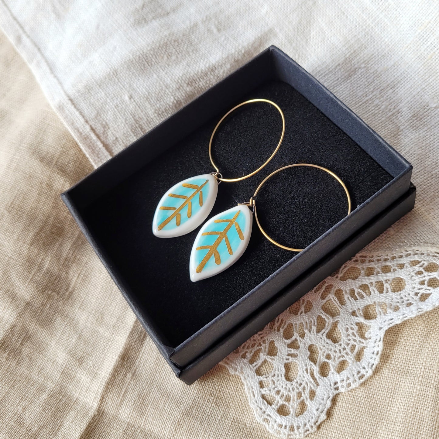 Porcelain dangle earrings with gold "Small white and light blue leaves"